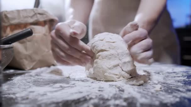 パンやピザを作るペストリーシェフの手で小麦粉テーブルを振りかける上で生地を混練クローズアップ — ストック動画