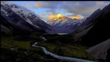 Bulutlar dağ tepelerinin etrafında daireler çiziyor. Dağ silueti. Gün doğumu hava manzarası. Bulutlu dağ sırtı