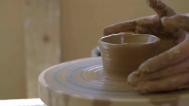 Çömlek çarkındaki adam geleneksel romantik iç mimari arka plan HD ile kilden kase seramiği yapıyor.