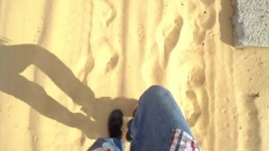 Afrika 'nın yerel tatil beldesi Sahara Çölü' nde rüzgarda yakın çekim kumları esiyor.