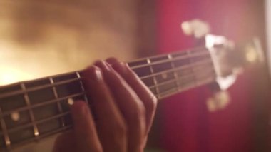 Yakın çekim gitarist el tıngırdatan elektro gitar çalan boyun teli elleri izole edilmiş.