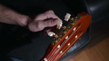 Yakın plan insan parmak ayarlı gitar. Mandallar perls bas akortçular ensesi müzik çalmak için izole