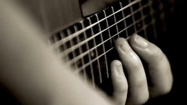Yakından gelen adam gitar çalıyor. Tanınmaz halde. Bas gitar çalıyor.