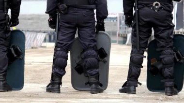 Zırhlı Polis Teşkilatı Polis Teşkilatı 'ndan kalkan ve copla halkın gösterisini bastırıyor.