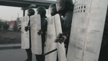 Zırhlı Polis Teşkilatı Polis Teşkilatı 'ndan kalkan ve copla halkın gösterisini bastırıyor.