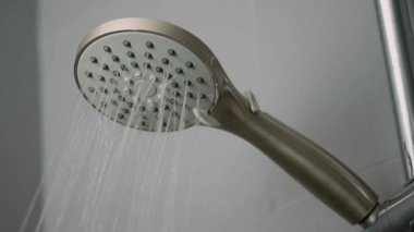 Yakın çekim duş başlığından su damlıyor. Banyodan dökülüyor. 4K görüntüler ferahlatıcı.