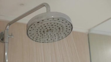 Gümüş krom duş başlığı su sıçratıyor. Banyo modern banyodan akıyor.
