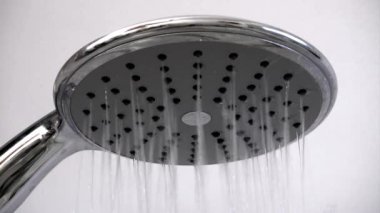 Gümüş krom duş başlığı su sıçratıyor. Banyo modern banyodan akıyor.
