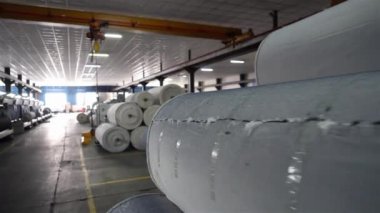 Fabrikada kumaş üretim iplikçikleri dokumak için malzeme üreten tekstil fabrikası ekipmanları üreten büyük iplik makaraları var.