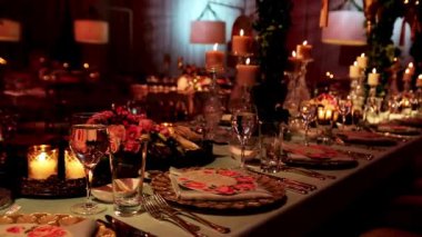 Şatafatlı düğün iç mimarisi çiçeklerle süslenmiş masa dekorasyonu iç mekan masa dekorasyonu şampanya flüt mumlarıyla detaylar ayarlanıyor.