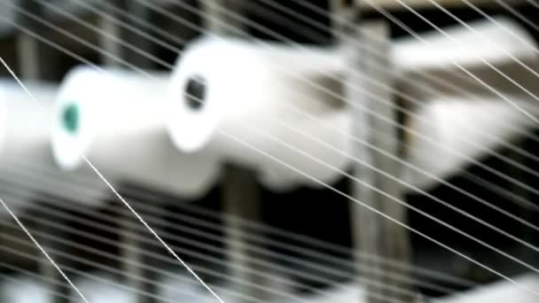 繊維工場機械工場機械の糸白い糸産業用ワーピングマシンのクローズアップスプールラック上の繊維をねじ作業中の繊維機器 — ストック動画