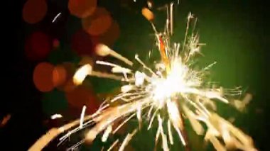 Kapalı tek bir maytap yanan neşeli kıvılcımlar mutlu bokeh pırıl pırıl ışık arka planı