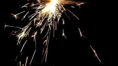 Kutlamada altın gibi parlak havai fişekler siyah arka planda mutlu bir parti tatili