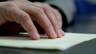 Kör insanlar görme engelli elleriyle kör alfabesiyle kitap okuyorlar.
