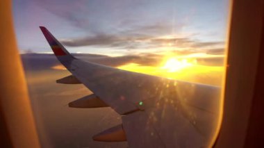 Uçak kanatlarının güzel manzarası ve seyahat için kırmızı akşam bulutlarının panoramik görüntüsü