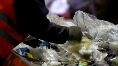 Bir atık işleme tesisinde geri dönüşüm için plastik ambalaj şişeleri diziliyor