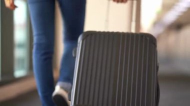 Havaalanındaki seyahat ve yıl sonu tatili konseptinde bavulla yürümek