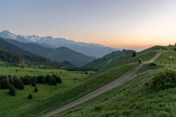Dağları ve mavi gökyüzü olan güzel bir manzara.