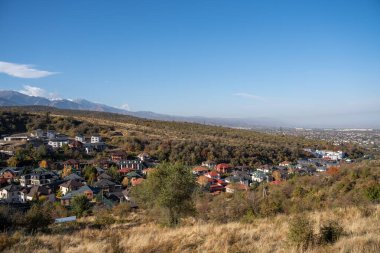 Arka planda küçük bir dağ köyü olan güzel sonbahar manzarası.