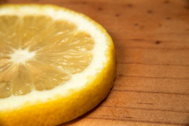 Tahta kesme tahtasındaki sarı limon dilimlerini kapatın, taze kesilmiş, lezzetli yemekler, limonata, limon tatlısı, limon suyu yapmak için kullanılır.