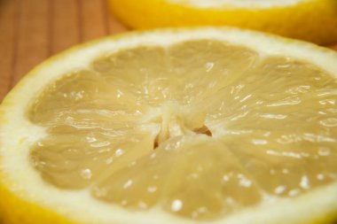 Tahta kesme tahtasındaki sarı limon dilimlerini kapatın, taze kesilmiş, lezzetli yemekler, limonata, limon tatlısı, limon suyu yapmak için kullanılır.