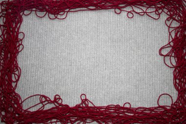 Örülmüş gri arkaplan üst görünümü ile kırmızı iplik kenarı metin için bir yer, iplik ve kopyalama alanı ile hobi ilgili ihtiyaçlar için