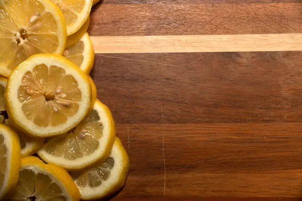 Tahta üzerinde sarı limon dilimleri, taze kesik, lezzetli yemekler, limonata, limon tatlısı, limon suyu yapmak için kullanılır.