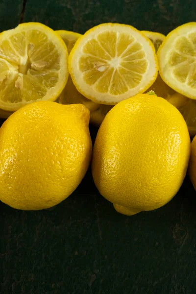 Row Whole Sliced Lemons Creating Border Green Rustic Textured Background — Stock Photo, Image