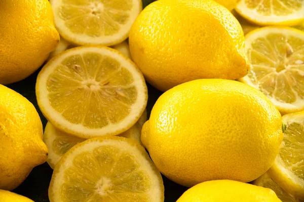 Row Whole Sliced Lemons Creating Vibrant Yellow Background — Stock Photo, Image