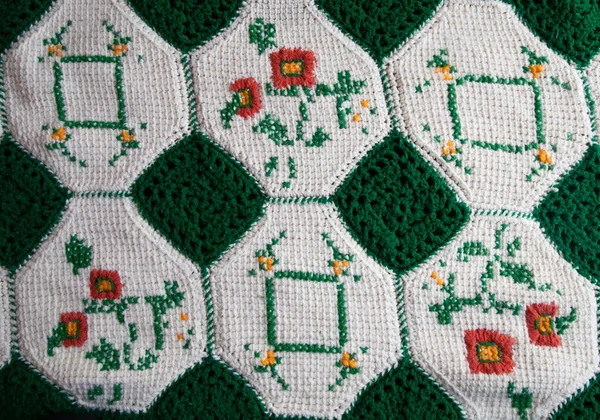 stock image close-up of grandma's crocheted or knitted green and white patch blanket, this blanket makes you think of grandma's house, it is cozy and warm, great for sick days, cold winter mornings, and lazy days on the couch.