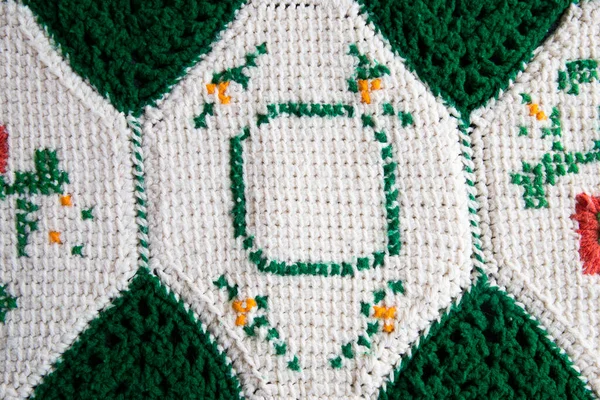 stock image close-up of grandma's crocheted or knitted green and white patch blanket, this blanket makes you think of grandma's house, it is cozy and warm, great for sick days, cold winter mornings, and lazy days on the couch.