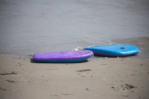 boogie board body board left abandoned on the beach object nobody copy space in front of ocean seaside