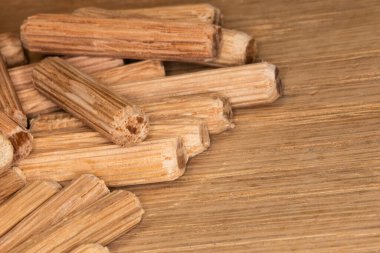 Meşe ağacının arka planında meşe çengelli iğne yığını, iki parça ahşap, eklem ve doğramacıyı birleştirmek için çengelli iğne.