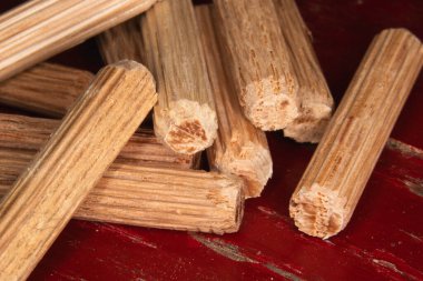 Kırmızı arka planda çengelli iğne yığını, tahta, eklem ve doğrama işlerinde kullanılan çengelli iğneler.