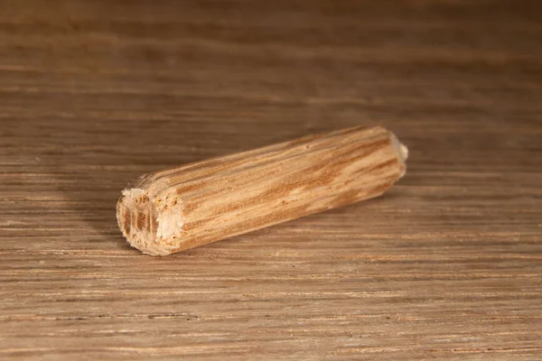 橡木背景上的单个橡木多斯针 用于连接两块木头 细木工的多斯针 — 图库照片