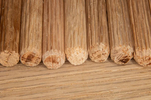 在橡木背景上的一排橡木多斯针 用于连接两块木头 细木工 — 图库照片
