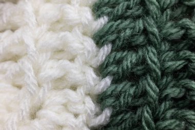 Adaçayı yeşili ve beyaz bir battaniyeye dikilmiş dikey örgü örgüleri büyükannemin evini hatırlatıyor, rahat ve sıcak bir arka plan.