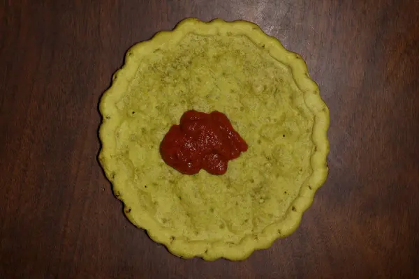 Ahşap masa üzerinde pizza soslu glütensiz pizza hamuru, yemek hazırlığı, akşam yemeği, bekarlık hastalığı, glüten alternatifi, süt ürünleri bedava.