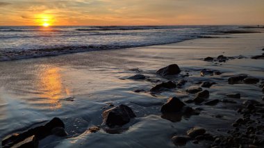 Güney Kaliforniya sahilleri, gün batımları, sörfçüler, gelgit havuzları ve palmiye ağaçları Encinitas California 'daki Swamis Resif Sörf Parkı' nda.