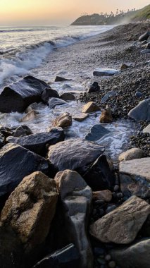 Günbatımları, sörfçüler, siluetler, gelgit havuzları, palmiye ağaçları ve okyanus kaya heykelleri ile Swamis Resif Sörf Parkı, Ay ışığı, Cardiff ve Beacons sahillerinde daha fazlası Encinitas California 'da.