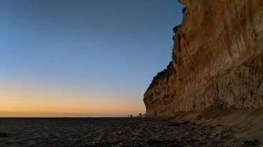 Southern California remote hidden beaches, sunsets, surfers, tide pools, beach cliffs, palms trees and fierce Winter storms at Swamis Reef Surf Park in the Encinitas coastal area about 25 miles north of San Diego. clipart