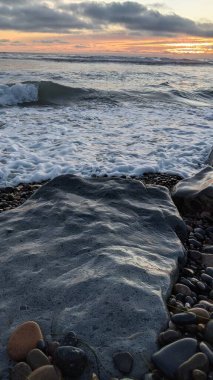 Swamis Resifi - Güney Kaliforniya plaj sahneleri San Diego 'nun kuzeyinde - Günbatımı, sörfçüler, gelgit havuzları, dalgalar, kayalar, kum ve palmiye ağaçları Encinitas California' daki Swamis Resif Sörf Parkı 'nda.