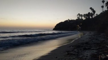 Gün batımından sonra Swamis Point. Güney Kaliforniya 'da günbatımları, sörfçüler, gelgit havuzları, palmiye ağaçları ve San Diego' nun 25 mil kuzeyindeki Encinitas sahilindeki Swamis Resif Sörf Parkı 'ndaki plaj soyutlamaları gözlerden uzak plajlar vardı..