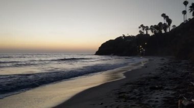 Gün batımından sonra Swamis Point. Güney Kaliforniya 'da günbatımları, sörfçüler, gelgit havuzları, palmiye ağaçları ve San Diego' nun 25 mil kuzeyindeki Encinitas sahilindeki Swamis Resif Sörf Parkı 'ndaki plaj soyutlamaları gözlerden uzak plajlar vardı..