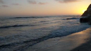 Gün batımından sonra Swamis Point. Güney Kaliforniya plajları, günbatımları, dalgalar, sörfçüler, gelgit havuzları, bulutlar ve palmiye ağaçları Encinitas California 'daki Swamis Resif Sörf Parkı' nda. San Diego 'nun 25 mil kuzeyinde yer alıyor..