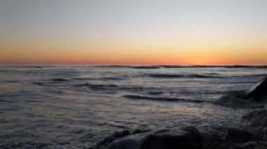 Swamis Sahili 'nde fırtınalı bir gün batımı. Encinitas California 'daki Swamis Resif Sörf Parkı' ndaki güzel sahil günbatımları, okyanus dalgaları, sörfçüler, gel-git havuzları, palmiye ağaçları ve kaya soyutlamaları ile San Diego 'nun kuzeyindeki tenha sahiller..