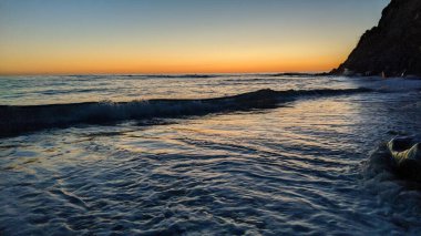 Güney Kaliforniya 'da gizli plajlar, gün batımları, sörfçüler, gelgit havuzları, sahil kayalıkları, palmiye ağaçları ve San Diego' nun 25 mil kuzeyindeki Encinitas sahilindeki Swamis Kayalık Sörf Parkı 'nda şiddetli kış fırtınaları..