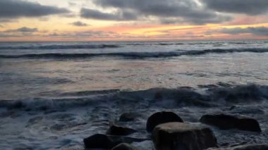 Swamis Sahili 'nin Erimiş Kayalıkları. 50 yıl önce, Swamis Resif Parkı Encinitas 'taki sörf karışımında eski nehir kayaları tarafından çevrelenmiş erozyon kontrol kayaları kıyıya bırakıldı..