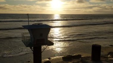 Deniz kenarındaki kule 19. Günbatımları, sörfçüler, siluetler, gelgit havuzları, palmiye ağaçları ve Encinitas California 'daki Cardiff plajında okyanus taşı heykelleri olan Güney Kaliforniya sahneleri.