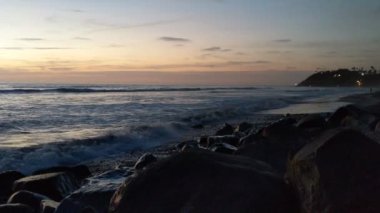 Deniz kenarındaki kule 19. Günbatımları, sörfçüler, siluetler, gelgit havuzları, palmiye ağaçları ve Encinitas California 'daki Cardiff plajında okyanus taşı heykelleri olan Güney Kaliforniya sahneleri.